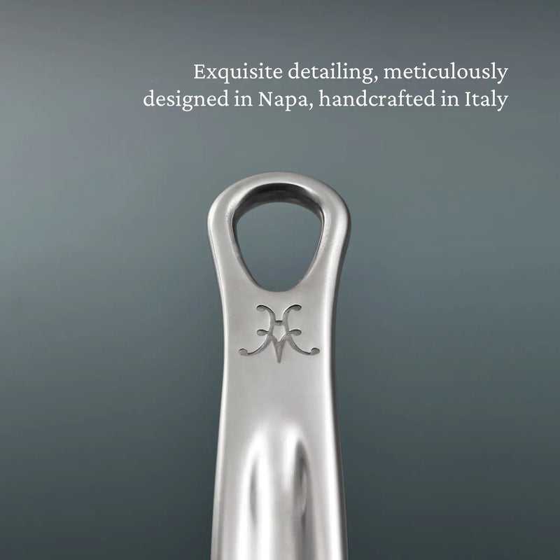 Close-up of a polished stainless-steel wine-bottle opener, branded with a decorative emblem, reflecting exquisite detailing and craftsmanship from Napa and Italy.