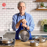 Middle-aged man in kitchen holding Hestan | Titanium Essential 5-Piece Cookware Set, showcasing its durability and ergonomic design for Athens Cooks.