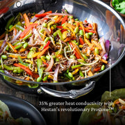 Hestan NanoBond | Cookware, 14 Titanium Chef's Pan showcasing stir-fry, emphasizing ProCore™ technology's superior heat conductivity for effective cooking.