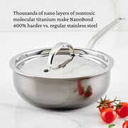 Hestan | Cookware, 2qt Saucier Pan + Lid, featuring resilient molecular titanium construction, sits on a countertop with cherry tomatoes, showcasing its innovative, durable design.