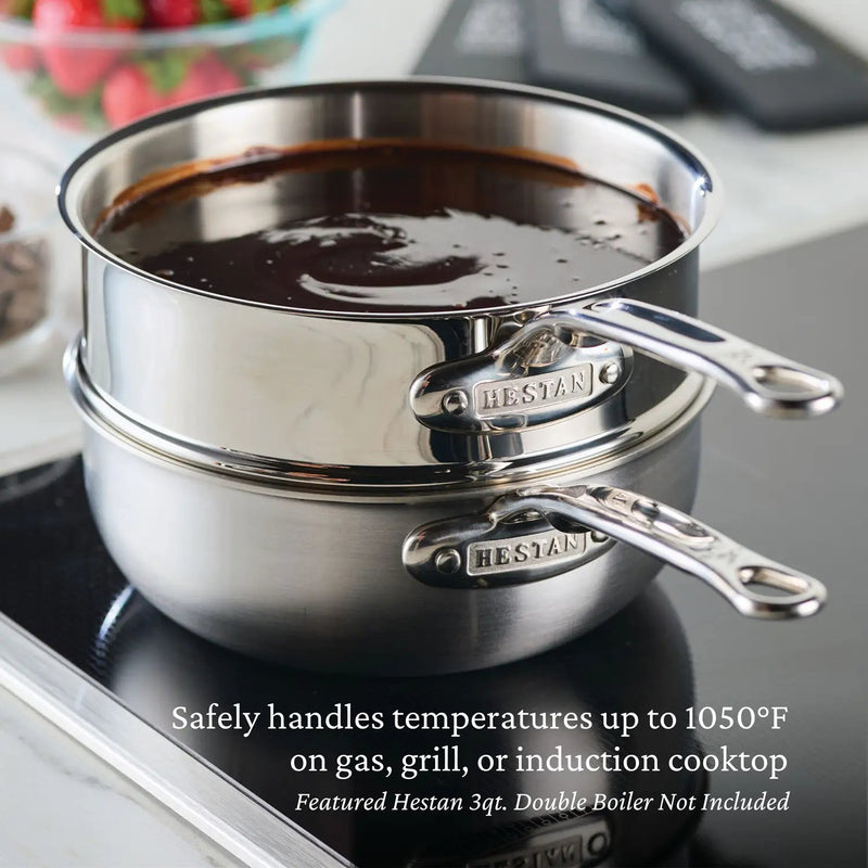 Hestan NanoBond 2qt Saucier Pan with Lid displayed on an induction cooktop with a double boiler, showcasing its high-temperature resilience and durable stainless steel construction.