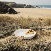 Emile Henry Deep Flan & Tart Dish, 1.3QT, showcased with a pie slice in a coastal setting, highlighting its versatility and elegance for perfect baking.