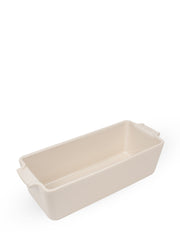 Peugeot | Appolia Loaf Pan: Cream-colored ceramic baking dish with flared handles, ideal for evenly cooking and presenting breads.