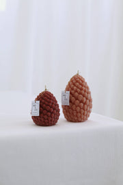Mo&Co Home Exclusive: Sculpted Beeswax Pine Cones in two sizes, showcasing elegant craftsmanship with a burgundy and muted pink design, perfect for holiday décor.