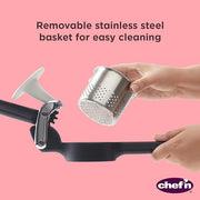 Hand holding the Chef'n Potato Ricer, a metal kitchen tool for mashing potatoes, available at Athens Cooks.