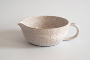 RachaelPots - Salad Dressing Bowl: Pink, a white speckled ceramic bowl with a handle, garlic scraper, and pour spout, ideal for dressings and marinades.