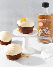 Runamok Mini Sparkle Syrup bottle beside cupcakes with white frosting, highlighting a sweet, specialty food product from Athens Cooks.