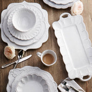 Bella Bianca Beaded Mug on a table with white plates and silverware, showcasing its exquisite Italian stoneware design, perfect for enhancing any dining experience.