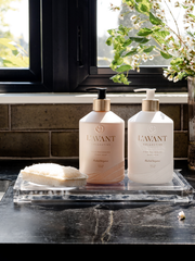 L'AVANT Collective - High Performing Hand Soap - Blushed Bergamot bottles on a counter with a sponge, highlighting elegant design and luxurious scent for a refined washing experience.