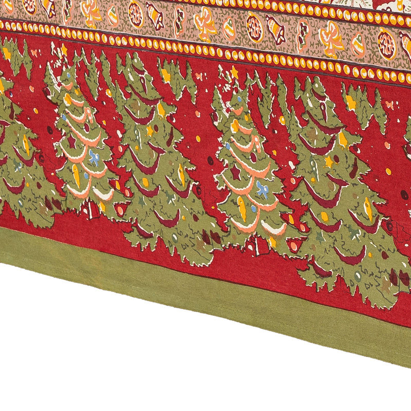 Couleur Nature - Noel Red & Green tablecloth featuring stylized evergreen trees and holiday motifs on red background, handprinted French linen, 59 x 86.