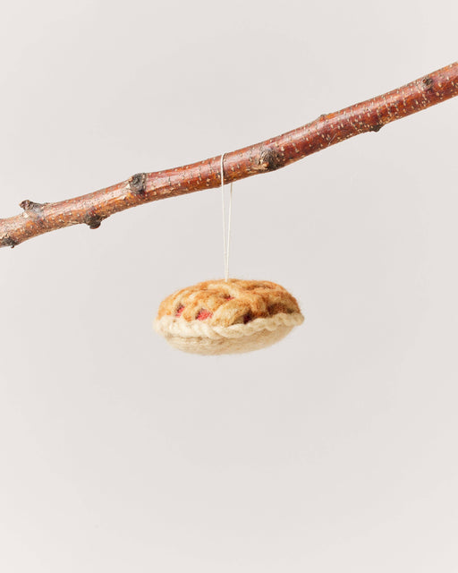 Farmhouse Pottery - Granny's Apple Pie Felt Ornament, a handcrafted wool decor piece, hangs from a branch, showcasing intricate lattice detail. Perfect for kitchen-themed decoration.