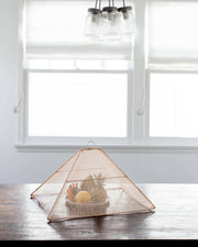 NEEPA HUT | Collapsible Woven Food Tent - Rose Pink, shown as a pentagon-shaped cover on a table, highlighting its elegance and functionality for outdoor dining.