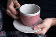 RachaelPots - 18 Oz Jumbo Mug: Nude/White, hand-thrown stoneware mug with thumb rest, held by a person, showcasing its size and craftsmanship.