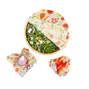 Bee's Wrap - New! Garden Party - Assorted 3 Pack, featuring a salad bowl wrapped in reusable fabric, showcasing summer produce preservation for eco-friendly kitchen storage.