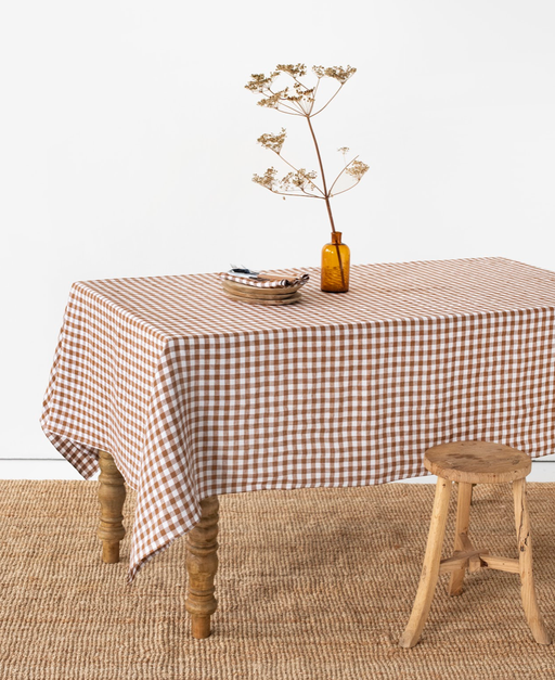 MagicLinen - Linen tablecloth in Cinnamon gingham: 59x59, featuring a checkered pattern with a vase of dried flowers, enhancing your dining space's warmth and style.