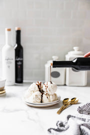 Kosterina - Dark Chocolate Balsamic Vinegar (375ml) being poured over ice cream, enhancing the dessert with its rich, velvety texture and intense aromatic notes.