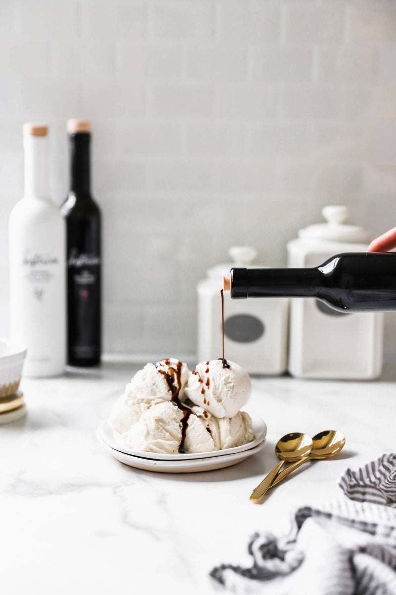Kosterina - Dark Chocolate Balsamic Vinegar (375ml) being poured over ice cream, enhancing the dessert with its rich, velvety texture and intense aromatic notes.