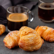 Nicola's Marketplace | Individual Mini Italian Sfogliatelle Pastries with ricotta and orange peel, accompanied by two espresso cups, showcasing a gourmet breakfast treat.