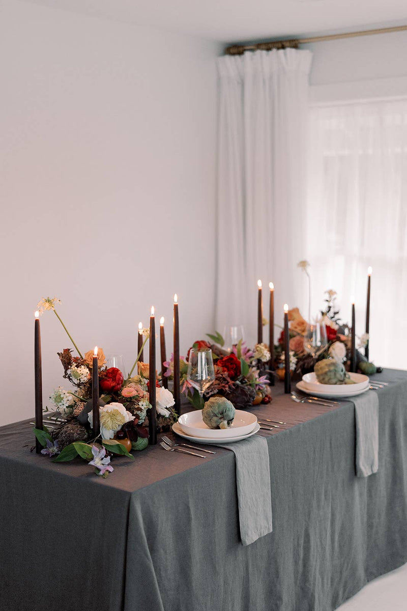 Mo&Co Home - Chestnut | Dipped Beeswax Taper Candles | All Natural: 14 Inch, elegantly lit on a dining table, enhancing a sophisticated dinner setting with their warm glow.