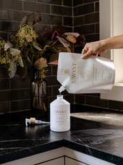 L'AVANT Collective - High Performing Dish Soap - Blushed Bergamot being poured into a sleek white bottle, showcasing its luxurious and eco-friendly refill design.