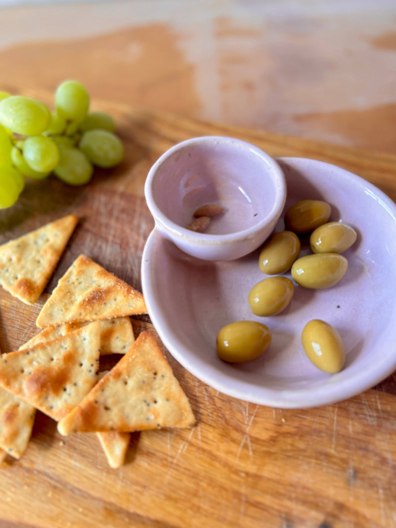 ROB Ceramics - Olive Serving Bowl Handmade: White, shown with olives and crackers, features a lavender-glazed design and a separate section for pits, ideal for entertaining.