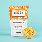 Poppy Hand | Crafted Popcorn - Pimento Cheese flavor, 3 oz bag, with a bowl of cheesy popcorn, embodying Southern culinary charm from Athens Cooks.