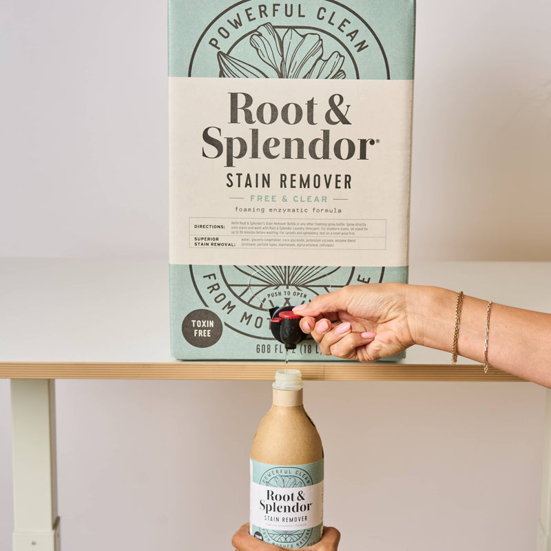 Root and Splendor - Bulk Stain Remover: 18 L carton with spigot dispensing into recycled bottle, labeled “Powerful Clean,” ideal for sustainable, refillable use.