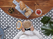 Le Parfait | Super Terrine, 750ml jar held above rustic bread, olives, and tomatoes; perfect for preserving and enhancing culinary creations.