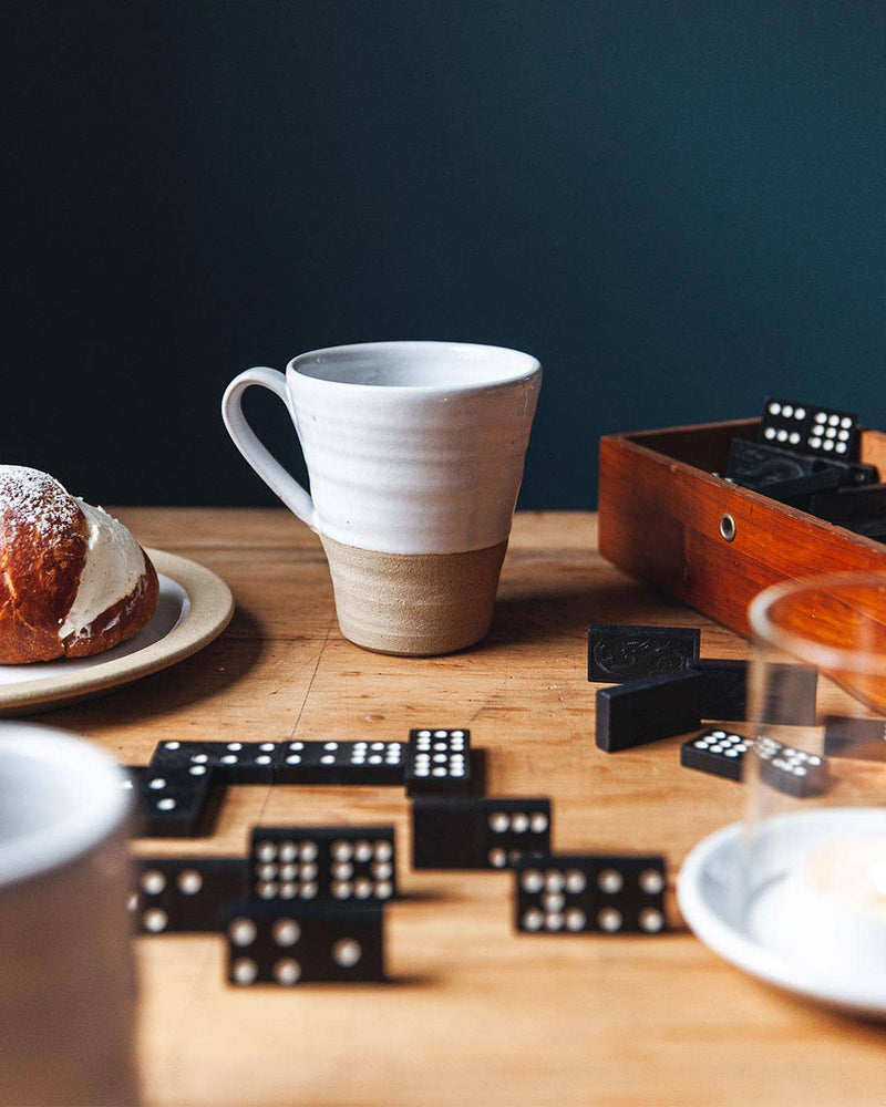 Farmhouse Pottery - Tall Silo Mug: Single, showcased in a cozy tabletop scene with dominoes and a pastry, ideal for enjoying hot drinks in style.