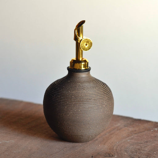 Rose Line Pottery Oil Bottle in natural brown, features a gold-metal pump sprayer, ribbed design, handcrafted for olive oil storage, 14-ounce capacity, signed by potter.