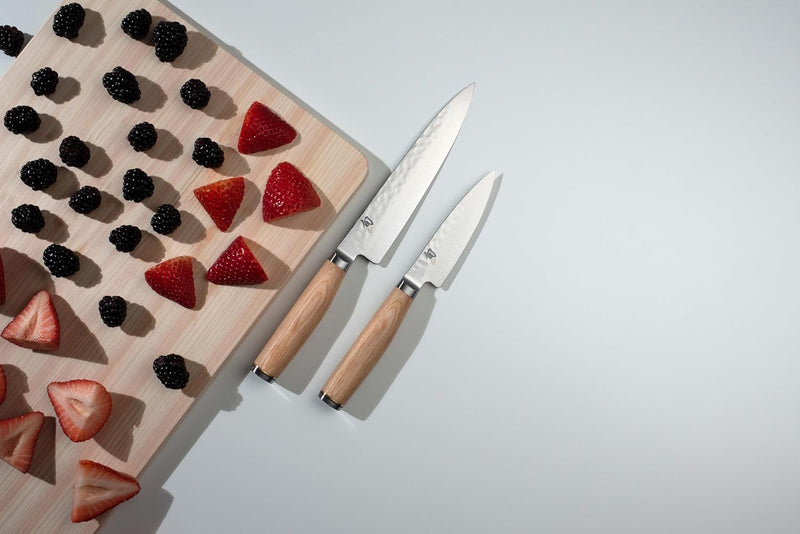 Shun Premier Blonde Starter Set, 3 Pc: Two Japanese-style knives with hammered blades and wooden handles next to a cutting board with arranged berries.