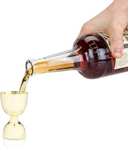 Viski | Belmont: Gold Canterbury Jigger being filled with liquid, showcasing its sleek design and measurement bands, ideal for precision cocktail crafting.