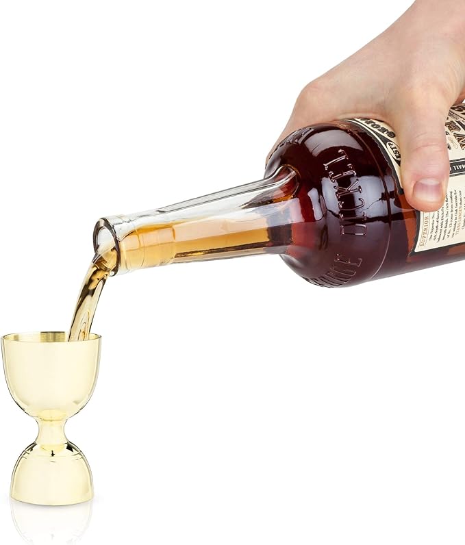 Viski | Belmont: Gold Canterbury Jigger being filled with liquid, showcasing its sleek design and measurement bands, ideal for precision cocktail crafting.