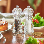 Peugeot | Paris Nancy Salt Mill, Acrylic, 12 inches, filled with coarse white salt, showcased on a table setting, emphasizing its elegant, crystal-clear design.