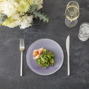 Fortessa | Arezzo 60 piece Place Setting elegantly displayed with a plate of salad and glasses of wine and water, suggesting a refined dining experience.