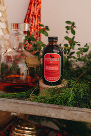 Bittermilk Bottling Co. - Bittermilk No.4 New Orleans Style Old Fashioned Rouge cocktail mixer next to a glass bottle, highlighting its artisanal packaging.