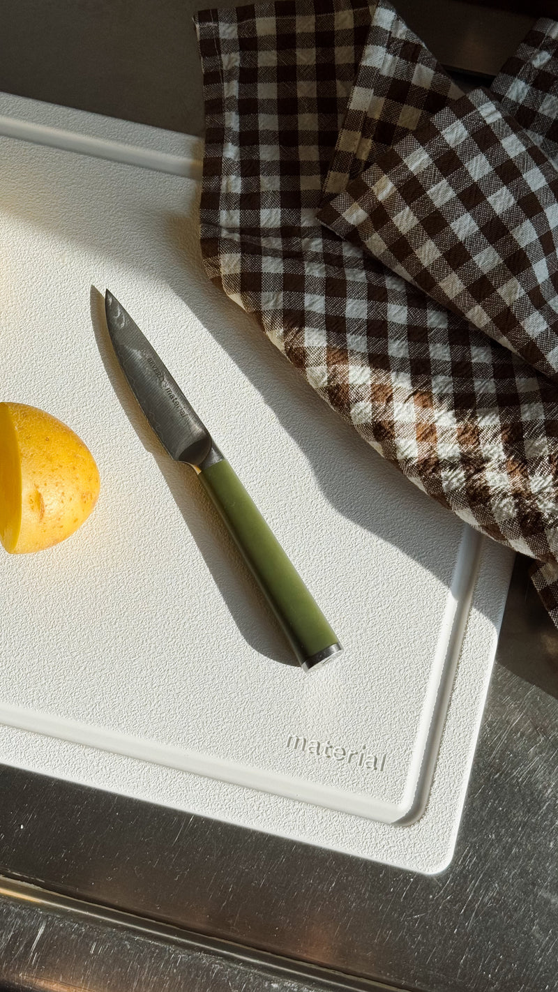 Material | The MK Free Board with a paring knife and potato, showcasing its plant-based, non-porous surface suitable for safe, efficient kitchen use.