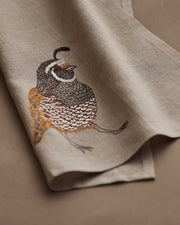 Coral & Tusk - Quail Tea Towel features exquisite quail embroidery on soft-beige linen, perfect for enhancing kitchen decor with nature-inspired elegance.