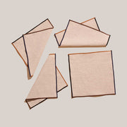 ATELIER SAUCIER - Dune Appetizer Napkins | Set of 4: Beige linen napkins with contrasting trim, arranged on a neutral background, showcasing elegant, versatile tableware.