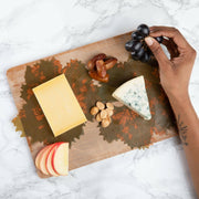 Formaticum | Cheese Board Liners - Large, featuring grape leaf design, held by person with tattoo, enhancing cheese presentations with wax-coated, biodegradable parchment.