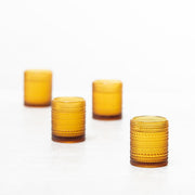 Fortessa | Jupiter Amber 10oz Double Old Fashioned Glass, part of a collection of glasses on a white surface, ideal for sophisticated barware enthusiasts.