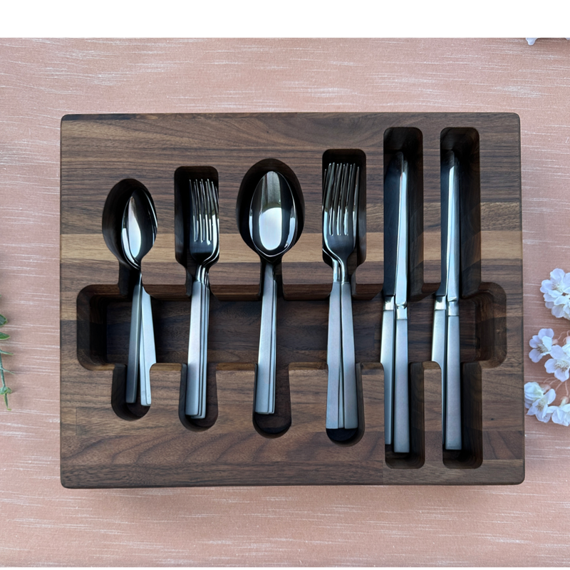 Loudblade - Custom Solid Walnut Wooden Flatware Drawer Organizer holding stainless steel flatware, displayed on a pink tablecloth with decorative blossoms.
