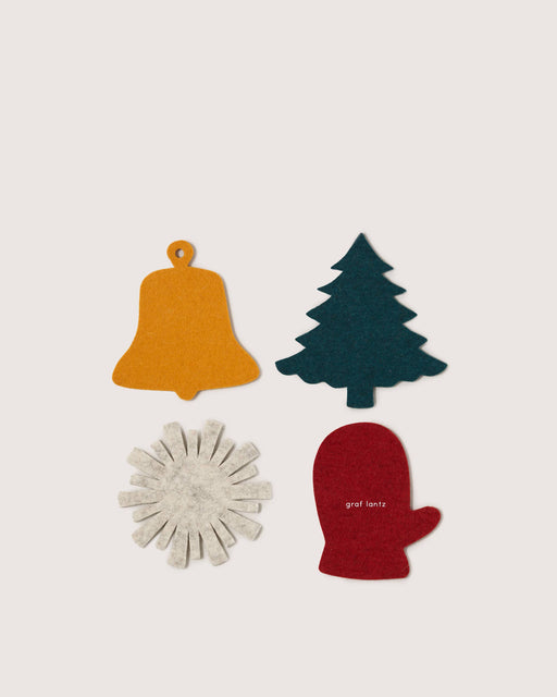 Graf Lantz - Merino Wool Coaster Multi 4 Pack - Deck the Halls featuring holiday-themed felt cutouts: bell, pine tree, snowflake, and mitten. Perfect for adding festive charm.