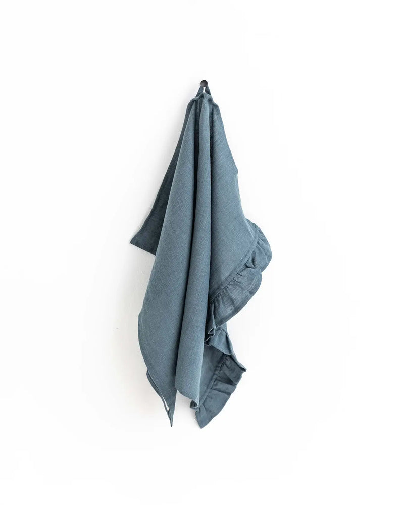 Ruffle trim tea towel by MagicLinen, hanging on a hook, showcasing its soft, durable linen fabric and stylish design. Ideal for adding elegance to any kitchen.