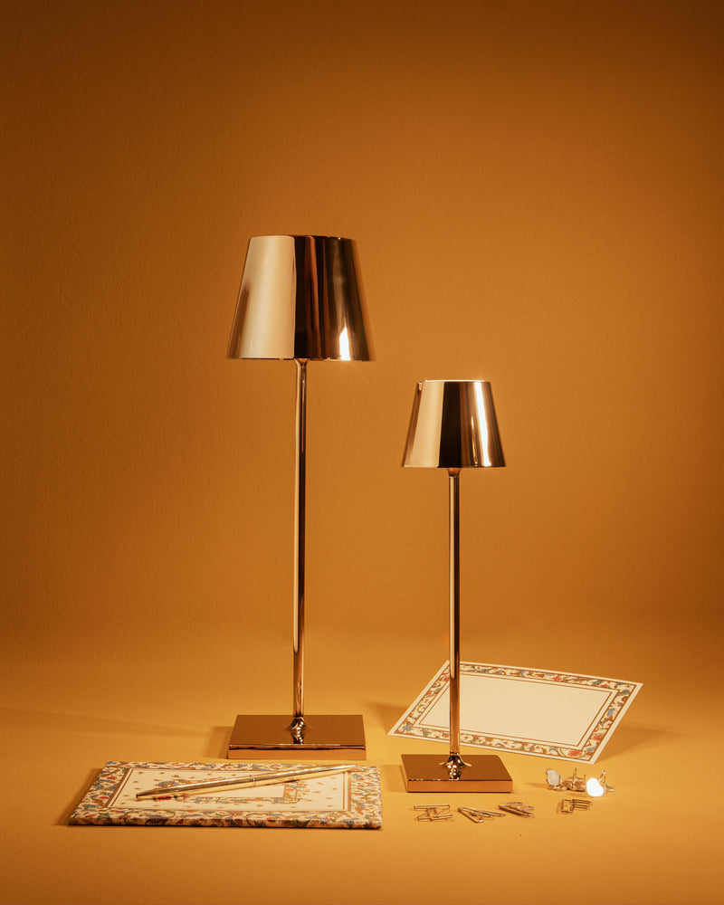 Zafferano America - Poldina Pro Micro Cordless Lamp: Sand, featuring a sleek design with a touch dimming function, displayed on a table with a matching lamp.