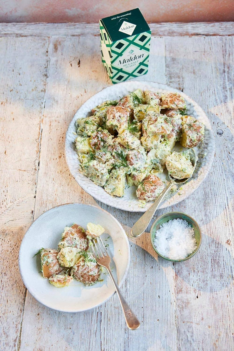 Wholesome Good - Maldon Sea Salt 8.5oz / 12: Single, showcased with a creamy potato salad, emphasizes its culinary use and premium quality.