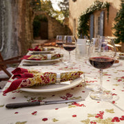 Couleur Nature - Gooseberry Red & Green tablecloth elegantly drapes a sunlit courtyard table, enhancing an al-fresco dining setup with casual elegance and French-inspired design.