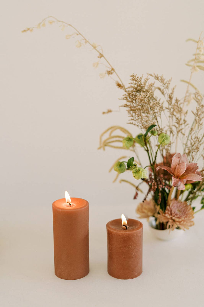 Mo&Co Home - 100% Beeswax Pillar Candles | Terra Cotta: 3x6 Inch, alongside a floral arrangement, showcasing a calming, eco-friendly home decor option.