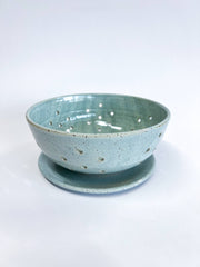 RachaelPots - Large Berry Bowl With Dish: Black, a handmade stoneware colander with floral drainage holes and matching drip tray, ideal for rinsing and displaying fruit.