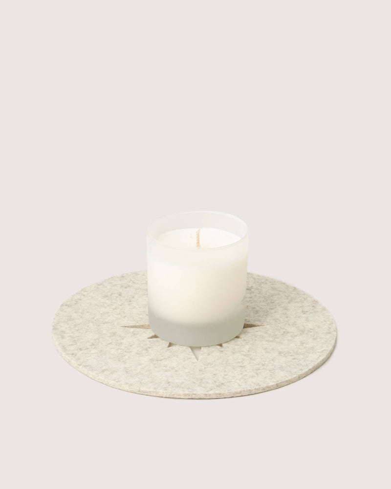 Graf Lantz - Merino Wool Bauble Trivet in Heather White under a white candle, showcasing minimalist design and heat protection for holiday celebrations.